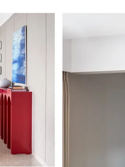 A detail shot showing the clean transition from a bold red console to a neutral textured wall. This demonstrates our approach to creating defined zones within an open-plan space.