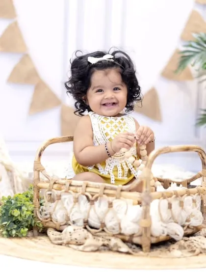 Sitting pretty in a wicker basket, this little girl enjoys her first birthday celebration. I use a variety of props to keep the session engaging and fun.