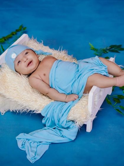 A happy little guy. This baby's sweet smile and relaxed pose make this blue-themed shot absolutely heartwarming.
