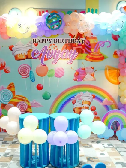 A wide view of the candy-themed birthday decor, featuring a colorful backdrop, balloon clouds, and rainbow details that fill the space with magic.