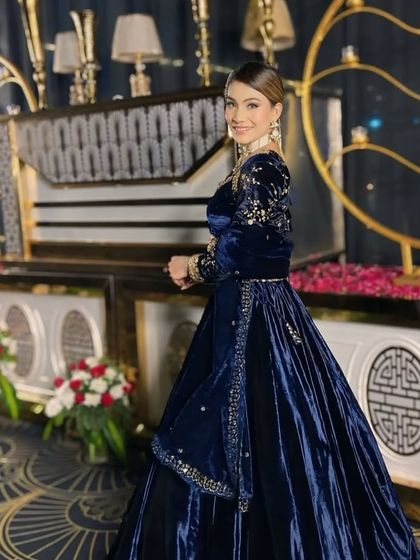 A smiling shot of the model in the royal blue velvet lehenga, showing how comfortable and elegant it is.