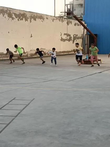 Young athletes participate in a running drill across the court. Speed and agility are key components of our basketball training program.
