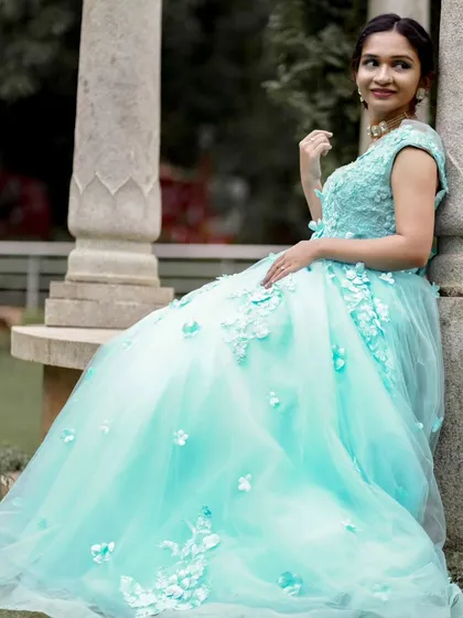 A solo portrait showcasing the elegance of the light blue ball gown. The full tulle skirt spreads out beautifully, making it ideal for creating princess-like photos.
