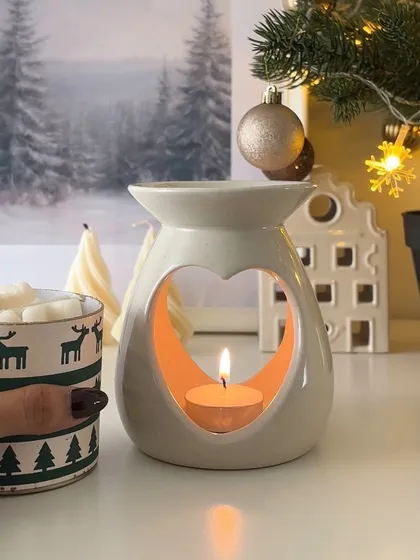 A cozy Christmas scene featuring our heart-shaped diffuser. It's perfect for melting our festive-scented wax melts.
