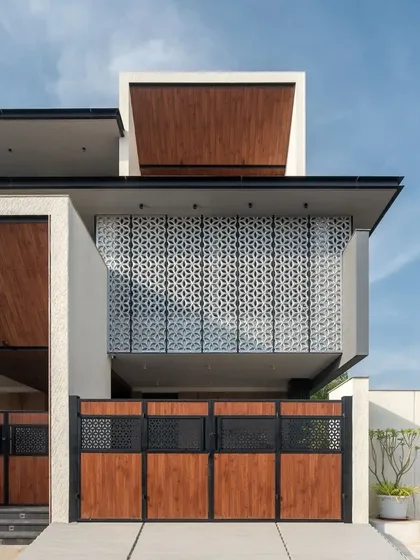 The facade of this home in Dindigul by Form Space Architects features an intricate jali screen that provides privacy for the upper level while creating a decorative element.