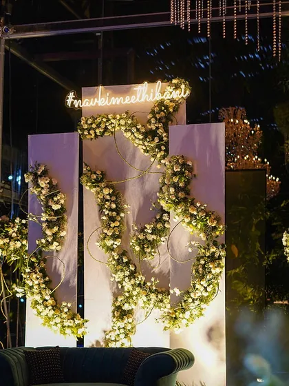 A custom floral installation on a paneled backdrop, with a neon sign of the couple's hashtag. This is a great example of personalized decor.