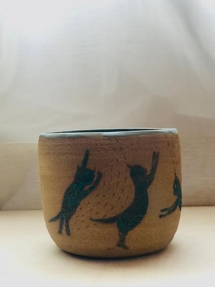 The "Midnight Mischief" cat bowl, showing the playful cats etched into the textured stoneware.