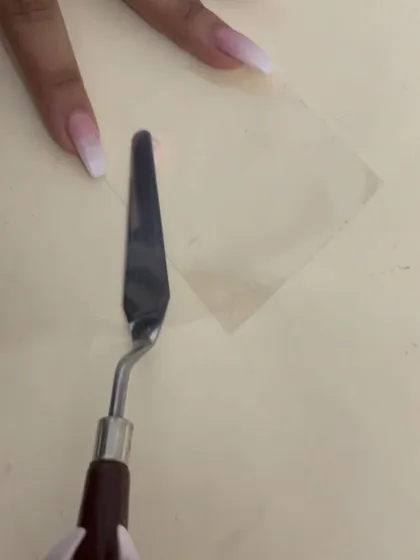 The process of creating a clean product swatch, using a palette knife and a clear acrylic sheet.