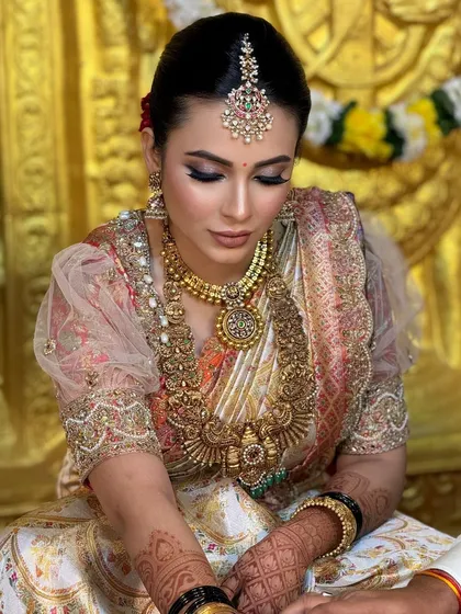 A candid shot of the bride during the ceremony. The makeup looks flawless even in the warm, ambient lighting of the venue.