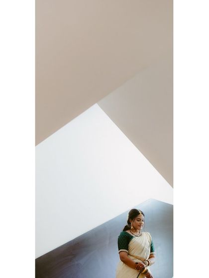 A minimalist bridal portrait against a wall with strong geometric lines. The simplicity of the background emphasizes the bride's graceful presence.
