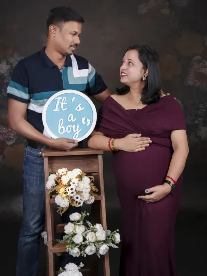 The couple announces "It's a boy" with a sign and a beautiful floral arrangement. This setup is perfect for sharing the happy news with family and friends.