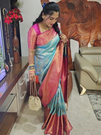 The rich pink pallu of Vijetha's saree drapes beautifully, adding a pop of color to her look.