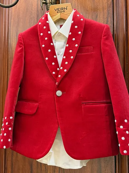 A closer look at our red velvet jacket. The pearl-like polka dots are individually attached, showcasing our commitment to handcrafted, high-quality details.