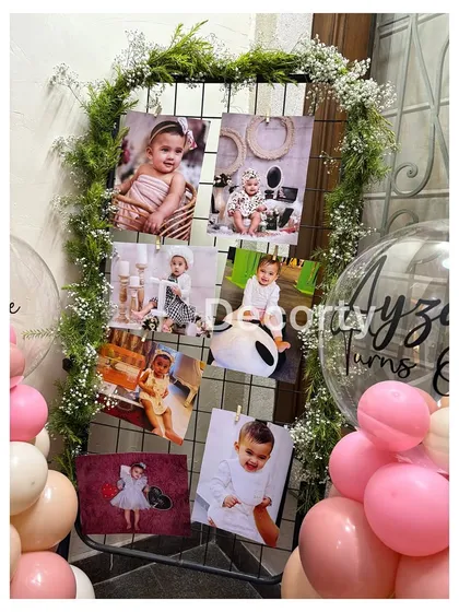 A close-up of the photo grid, adorned with greenery and baby's breath, showcasing precious monthly photos.