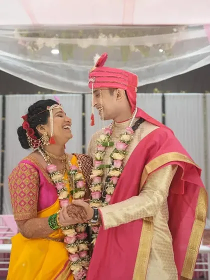 A moment of pure laughter and joy between the couple under the mandap during their Maharashtrian wedding.