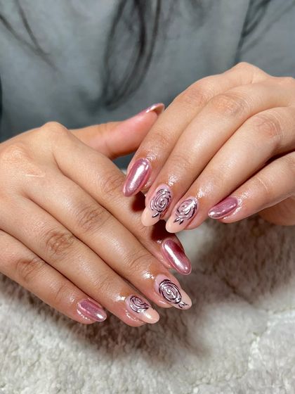 A beautiful set with a pearlescent pink base and hand-painted black rose outlines on the accent nails.