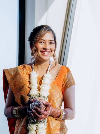 A bright, happy shot from the Mandvo ceremony. The natural light highlights her glowing skin and the simple, elegant makeup.
