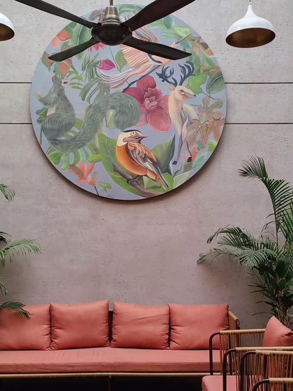 The circular canvas installed in its final location, bringing life and color to the serene outdoor seating area.