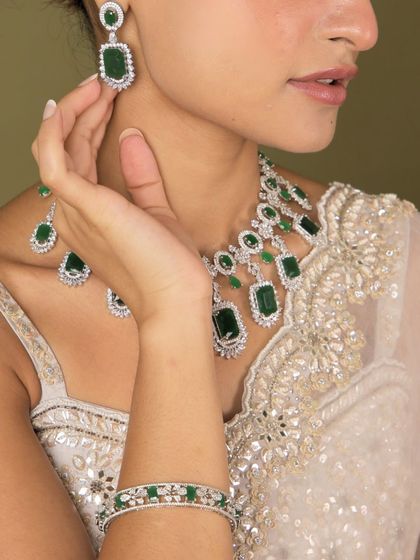 A detailed shot of our emerald and diamond necklace set, including the matching bangles. This shows how our pieces can be layered to create a rich and luxurious look.