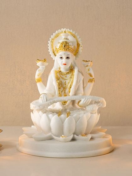 This elegant white resin sculpture of Goddess Saraswati, detailed with gold accents, embodies wisdom and artistry. It's a graceful addition to a study, library, or any space where you seek inspiration.