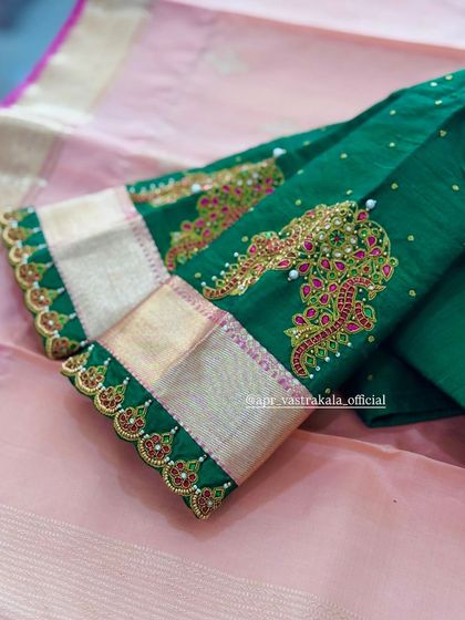 A green blouse with scalloped sleeve cuffs, detailed with pink and white stones.
