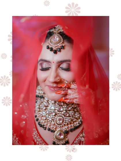 A close up shot through the veil, focusing on the stunning eye makeup and the heavy kundan jewelry.
