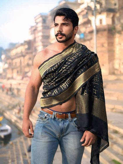 A powerful three-quarter portrait that highlights both the subject's physique and the spiritual significance of the Banarasi drape.
