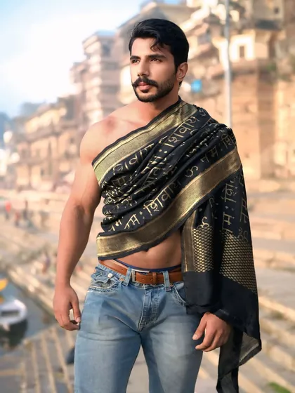 A powerful three-quarter portrait that highlights both the subject's physique and the spiritual significance of the Banarasi drape.