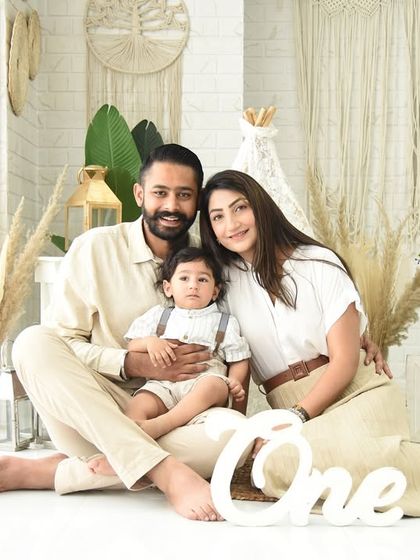 A beautiful family portrait celebrating their son's first birthday. The boho-themed setup adds a touch of style to this special memory.