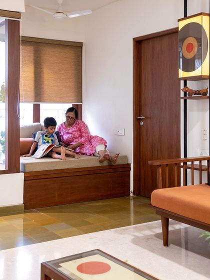 We believe in creating spaces for connection. This cozy window seat in a 4BHK apartment we designed has become a favorite spot for the family, perfect for reading stories or simply enjoying the view of the hanging garden outside.