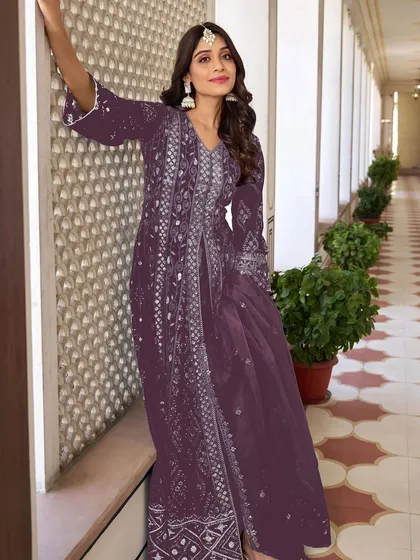 A stunning purple Anarkali with intricate thread, zari, and sequence work. The flowing silhouette and rich color make it a perfect choice for a sangeet or reception.