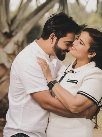 Sometimes the simplest moments are the most beautiful. This is a candid, romantic shot from a pre-wedding session in a park. The natural light and greenery provide a soft backdrop, allowing the couple's close embrace and gentle expressions to be the main focus.