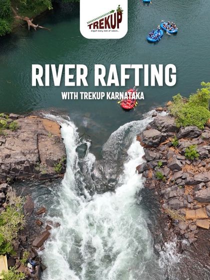 An aerial view of river rafting in Dandeli, showing the rafts navigating around a small waterfall in the river.
