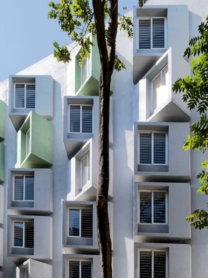The facade of a research center for Artificial Intelligence, featuring dynamic, three-dimensional window modules. These structures are not just aesthetic but also function as shading devices, optimizing natural light for the interior research spaces.