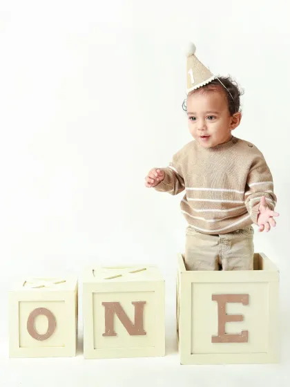 This little guy, wearing his birthday hat, looks ready to explore the world as he stands in his 'ONE' blocks.
