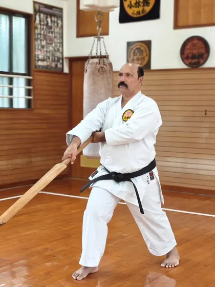 Here I am practicing with the Eku (oar), a traditional Okinawan Kobudo weapon, during a training session at the Honbu Dojo in Japan. Advanced training goes beyond empty hands to include the complete martial arts system.
