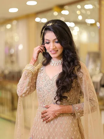 A candid moment showing off her beautiful open hairstyle with soft waves, perfect for an elegant engagement look.