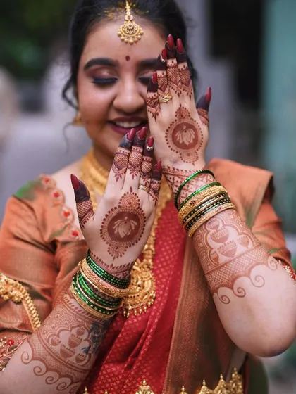 A happy bride-to-be showing off her stained engagement mehendi. The lotus mandalas have developed into a beautiful deep color.