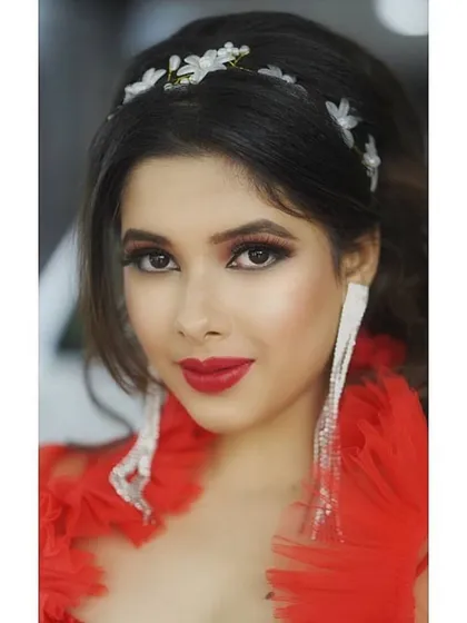 A bold and beautiful portrait with striking red lipstick and dramatic earrings. This look is designed to stand out in beauty campaigns and editorials.