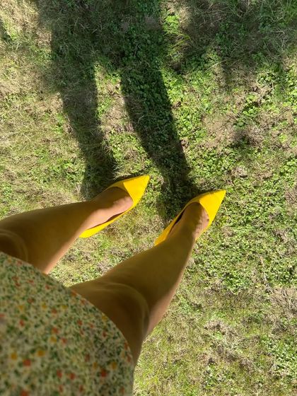 A fun shot showing off the pointed-toe yellow heels that perfectly match the handbag. Coordinating your accessories is a simple trick to make any outfit look more intentional.