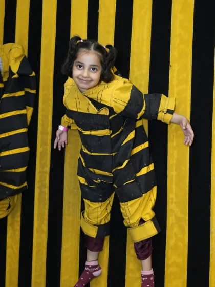 Another happy visitor enjoying the unique experience of our velcro wall, striking a pose while stuck.