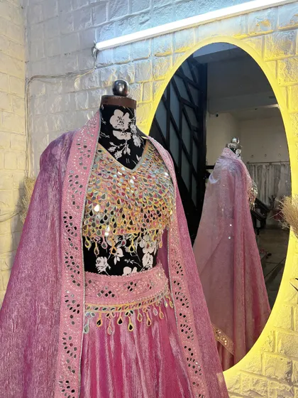 The cape-style dupatta adds a touch of drama and elegance to this beautiful mirror work lehenga.