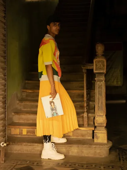 An editorial shot on a rustic staircase, blending high-fashion styling with a gritty, urban environment. The composition leads the eye through the frame, telling a story.