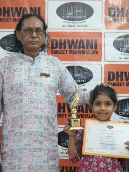 A senior guru with a young, talented student and her award.