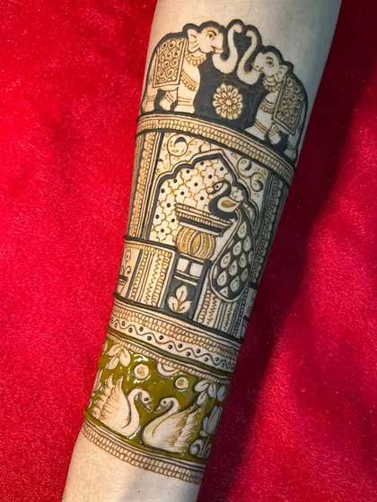 A startup design for a bridal arm, featuring majestic elephants, a peacock in a jharokha (window), and a pair of swans.