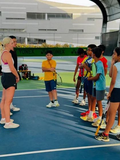 A group of young players gathered on court for a motivational talk. Exposure to professional athletes helps our students set realistic goals and cultivate mental strength.