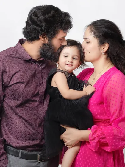 Kisses for their little girl. This photo is overflowing with love and affection.