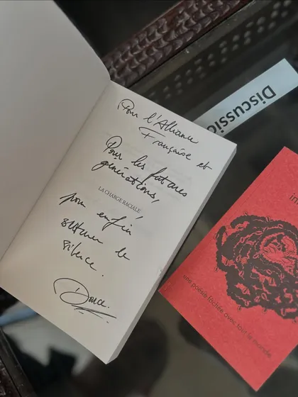 A signed dedication from author Douce Dibondo in her book, now part of our collection. These personal touches connect our readers directly to the authors.