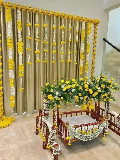 A classic and elegant jhula decoration for a home Janmashtami celebration. I used strings of fresh yellow marigolds and white rajnigandha flowers to create a beautiful backdrop for the cradle, which is also adorned with matching floral arrangements.