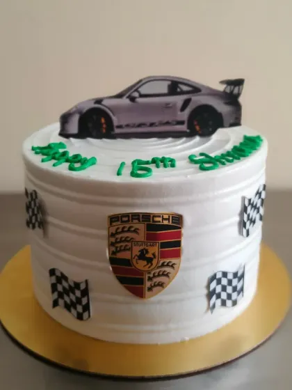 A sleek Porsche themed cake for a 15th birthday. The design includes the iconic Porsche crest, checkered flags, and a car topper.